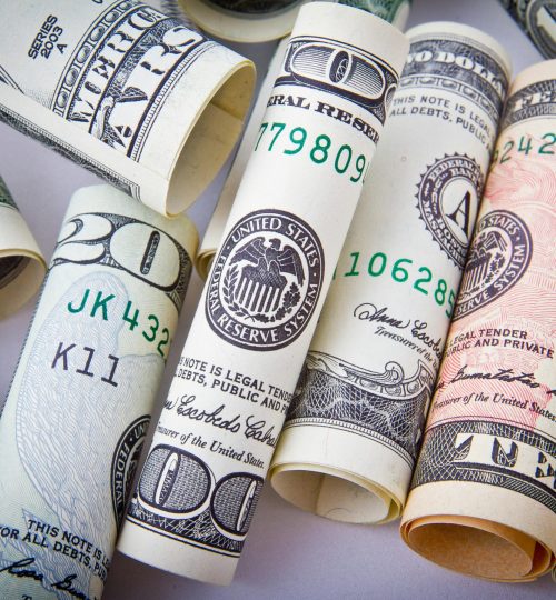 Close-up of rolled US dollar bills symbolizing wealth, financial success, and currency.